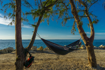 USA, Florida, Sleeping and relaxing in a hammock under two trees at key west beach at sunset