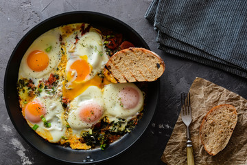 fried eggs with spinach, tomatoes and toasted bread.