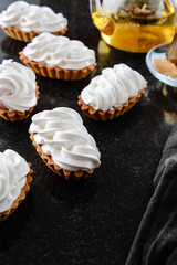 Sweet tartlet with cream on black background.