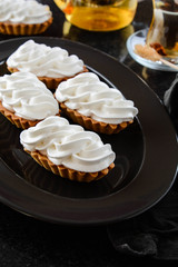 Sweet tartlet with cream on black background.