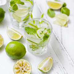 Caipirinha, mojito cocktail with lime, brown sugar, ice and mint leaves in beautiful glasses, cut...