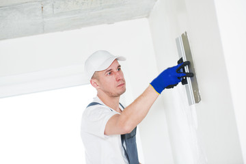 Plastering. Worker spackling a wall with putty