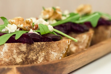 Slices of bread with roasted beetroot on light background - healthy vegetarian food- close up, macro shot.