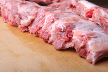 Raw Ribs on a rustic cutting board with salt, pepper and grinder for spices . copy space. Top View.