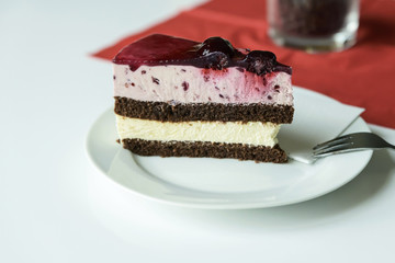 Delicious red white strawberry and a piece of cake on a white table.