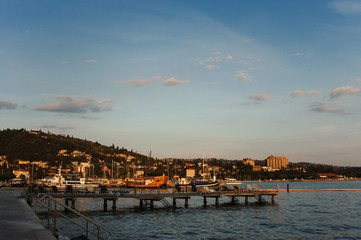 Fototapeta premium Marine with yachts and sail boats and town view at sunset. Portoroz