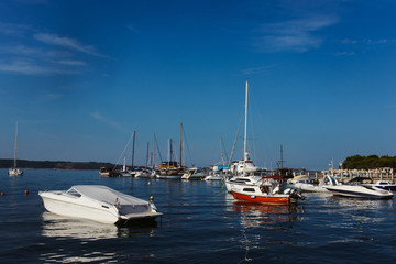 Obraz premium Yachts parking pier in Portoroz Slovenia. Bright blue water of Mediterranean sea on clear summer sky