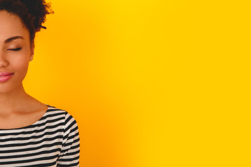 Young african woman isolated on yellow wall studio teen style relaxed
