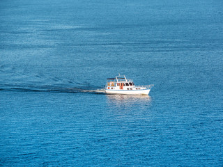 Fototapeta na wymiar Small boat on the sea or on the river. Blue water with small waves