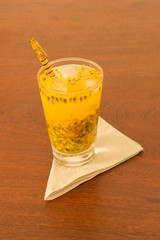 Glass with Passion Fruit Caipirinha made with brazilian cachaca. In the wood table with   checkered napkin - Brazilian National Drink 