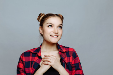 Body language and emotion. Portrait close up on a white background in studio. The young girl the blonde showing her heart filled with love and gratitude holding hands on her breast