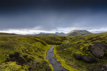 Dunkle Wolken über der moosbedeckten Landschaft im Hochland von Island