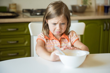 Cute little girl refuses to eat, pushes the plate