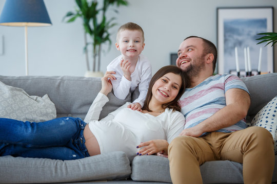 Photo of happy parents with small son on sofa