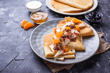 Pancakes crepes with different fruits and chocolate