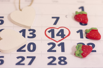 14th February marked with a heart on calendar and wooden pins with red hearts. Close up. St.Valentine's concept.