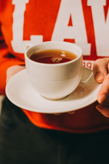 Close-up of a woman's hand holding a cup of hot tea