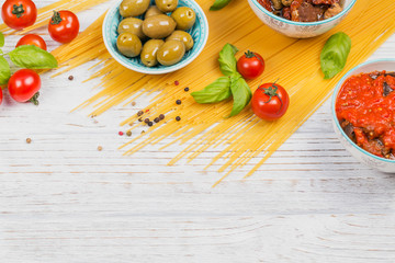 Ingredients for preparation pasta spaghetti - tomato, olive oil, spices, herbs, green olives, tomato sauce