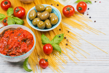 Ingredients for preparation pasta spaghetti - tomato, olive oil, spices, herbs, green olives, tomato sauce