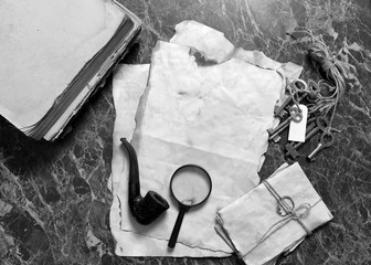 papers and book on detective work table with tools 