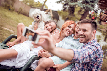 Fototapeta premium Happy family smiling at the camera with their dog .