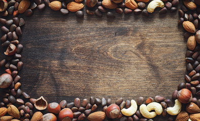 Different nuts on a wooden table. Cedar, cashew, hazelnut, walnu