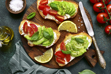 Toasts with avocado, tomato and feta cheese.Top view with copy space.
