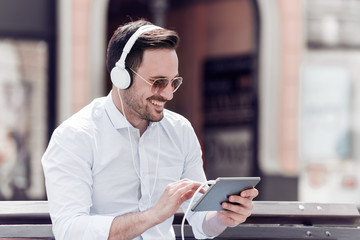 Man with headphones smiling and listening to music.