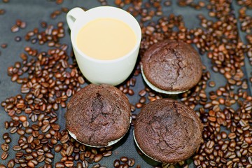 Dark muffins, cups of coffee and coffee beans on black background. Flat design. Coffee bar concept