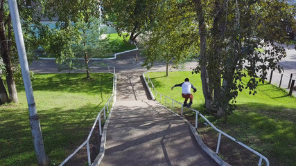 Aggressive inline roller blader grind on rail in skatepark outside. Clip. Summer extreme sport...