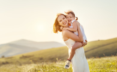 Happy family in summer outdoors.   mother  hug child daughter and laughing