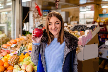 Portrait of smiling woman holding red apple