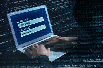 Hacker using laptop at table