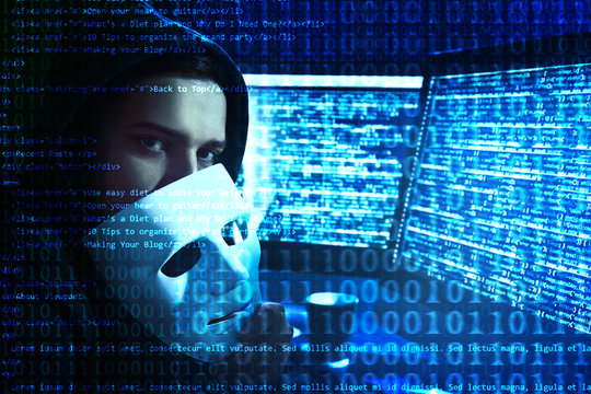 Hacker with mask near computer in dark room