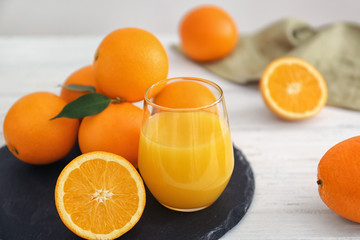 Glass with fresh orange juice and fruit on slate plate