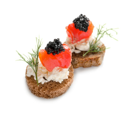 Delicious canapes with black caviar on white background