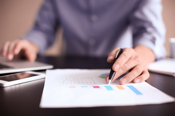 Man working at table in office, closeup. Financial trading concept