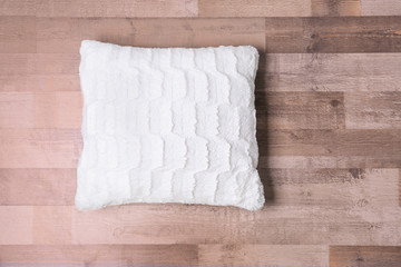 Stylish pillow on wooden floor