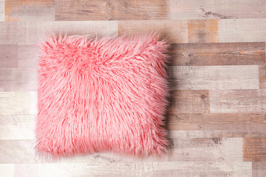 Fluffy pillow on wooden floor