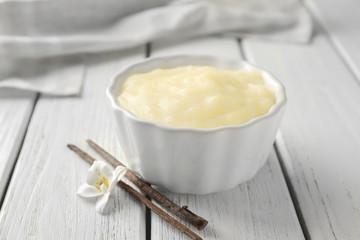 Ramekin with tasty vanilla pudding on table