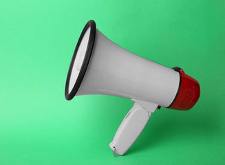 Electronic megaphone on color background