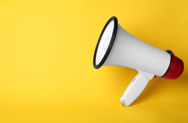 Electronic megaphone on color background