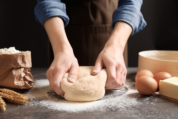 Woman kneading dough on table, closeup