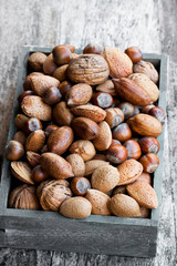 Various  nuts in wooden box on rustic table