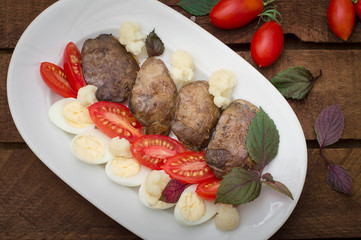 Fried chicken liver with vegetables and herbs. Wooden background. Top view