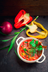 Borscht with meat and greens on the white plate. Traditional Ukrainian Russian red soup. Old black rustic background. Top view