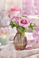 bunch of pink flowers in vase on the table in shabby chic style