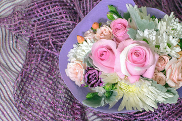 Obraz na płótnie Canvas Pretty bouquet of miniature roses on purple scarf
