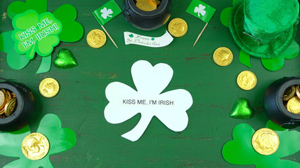St Patrick's Day leprechaun hat with decorations on green rustic wood table background overhead