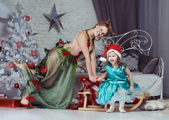 Young mother and her daughter in fancy Christmas costumes